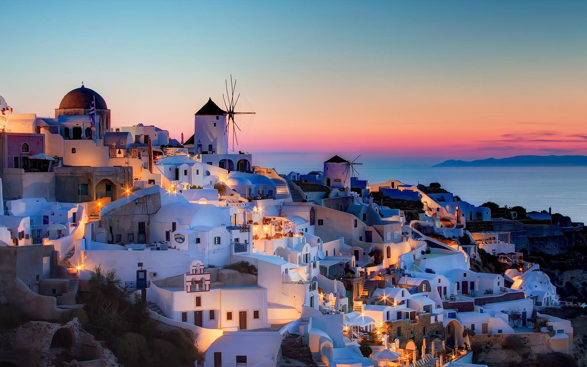 The sunset over a hillside of white buildings - Italy