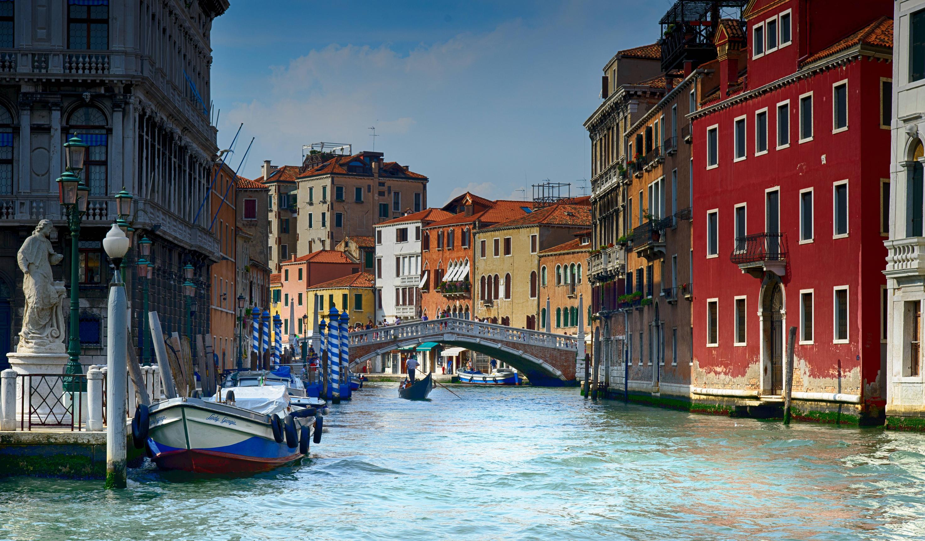 A boat in the water next to buildings - Italy