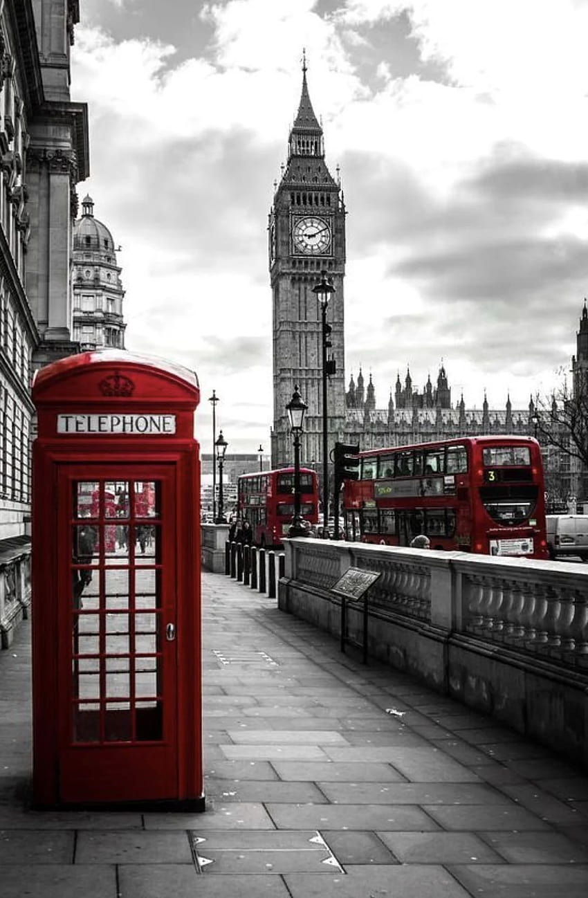 A red phone booth is in front of big ben - London