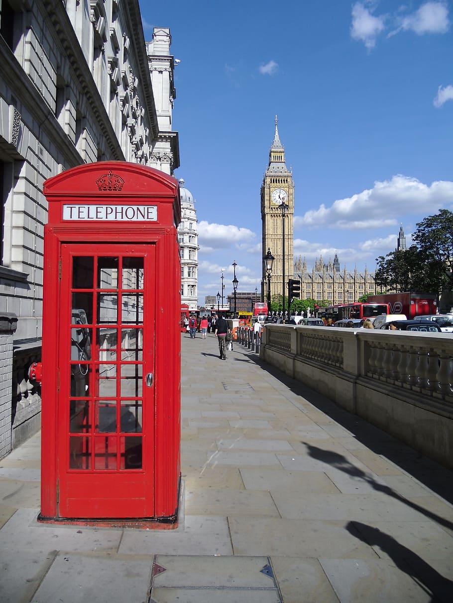 A red phone booth in front of big ben - London