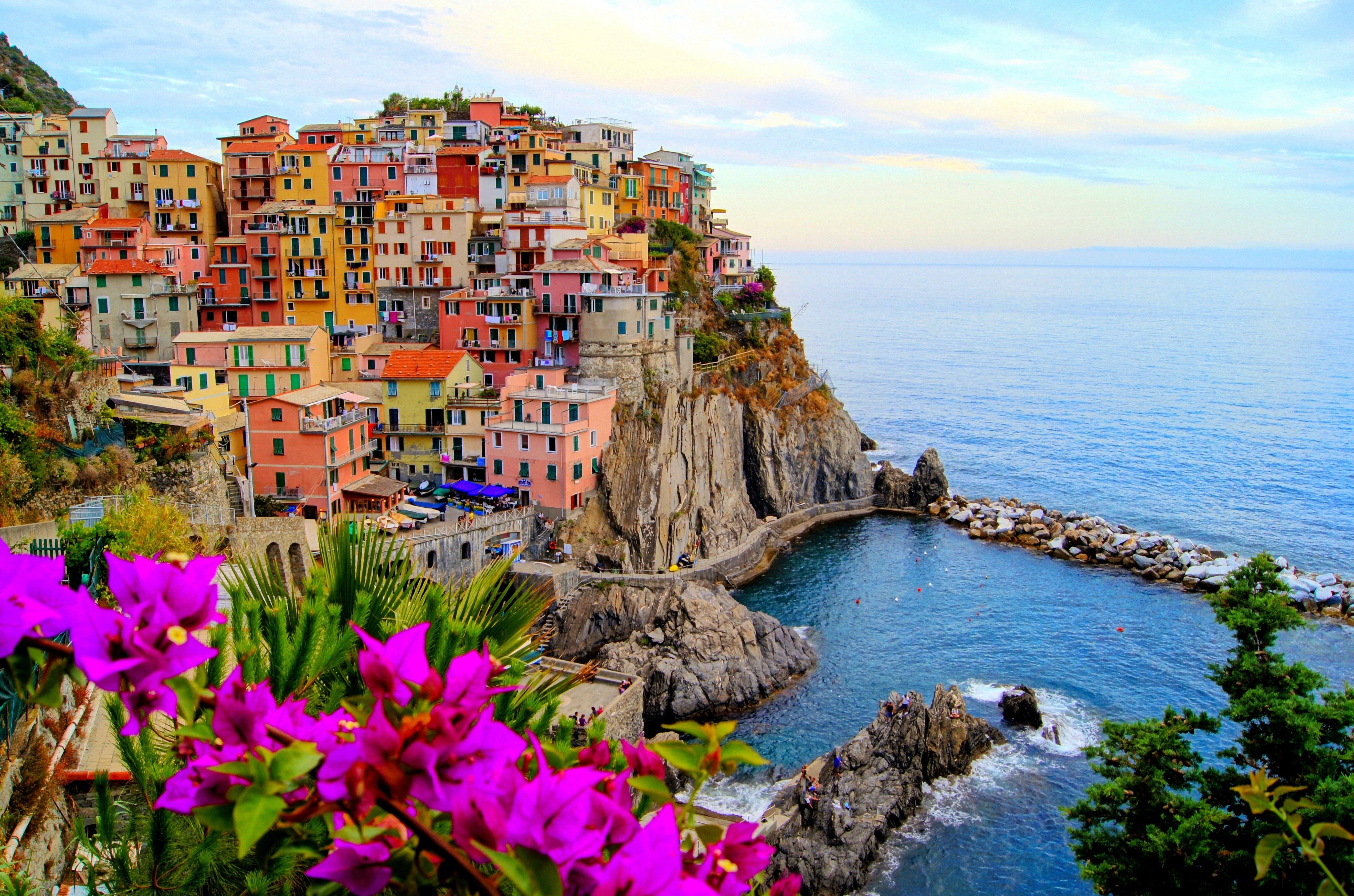 A cliffside town with bright houses overlooking the ocean - Italy