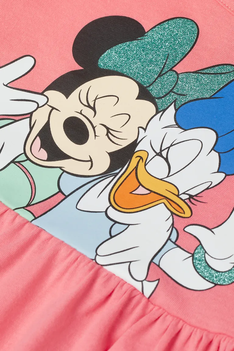 Close up of a Minnie Mouse and Donald Duck print on a pink fabric - Minnie Mouse