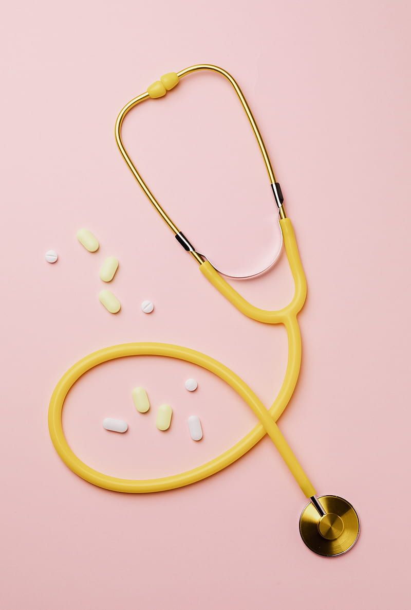 A yellow stethoscope with pills on it - Nurse