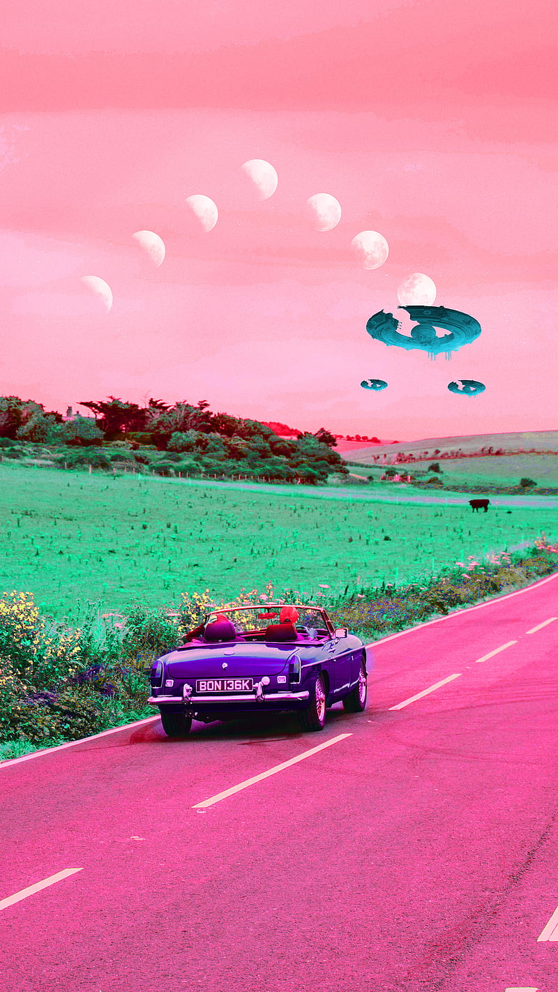 A car driving down the road with flying saucers in front of it - Road