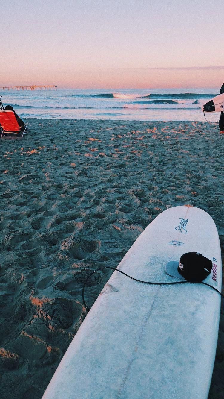 A surfboard on the beach at sunset - Surf