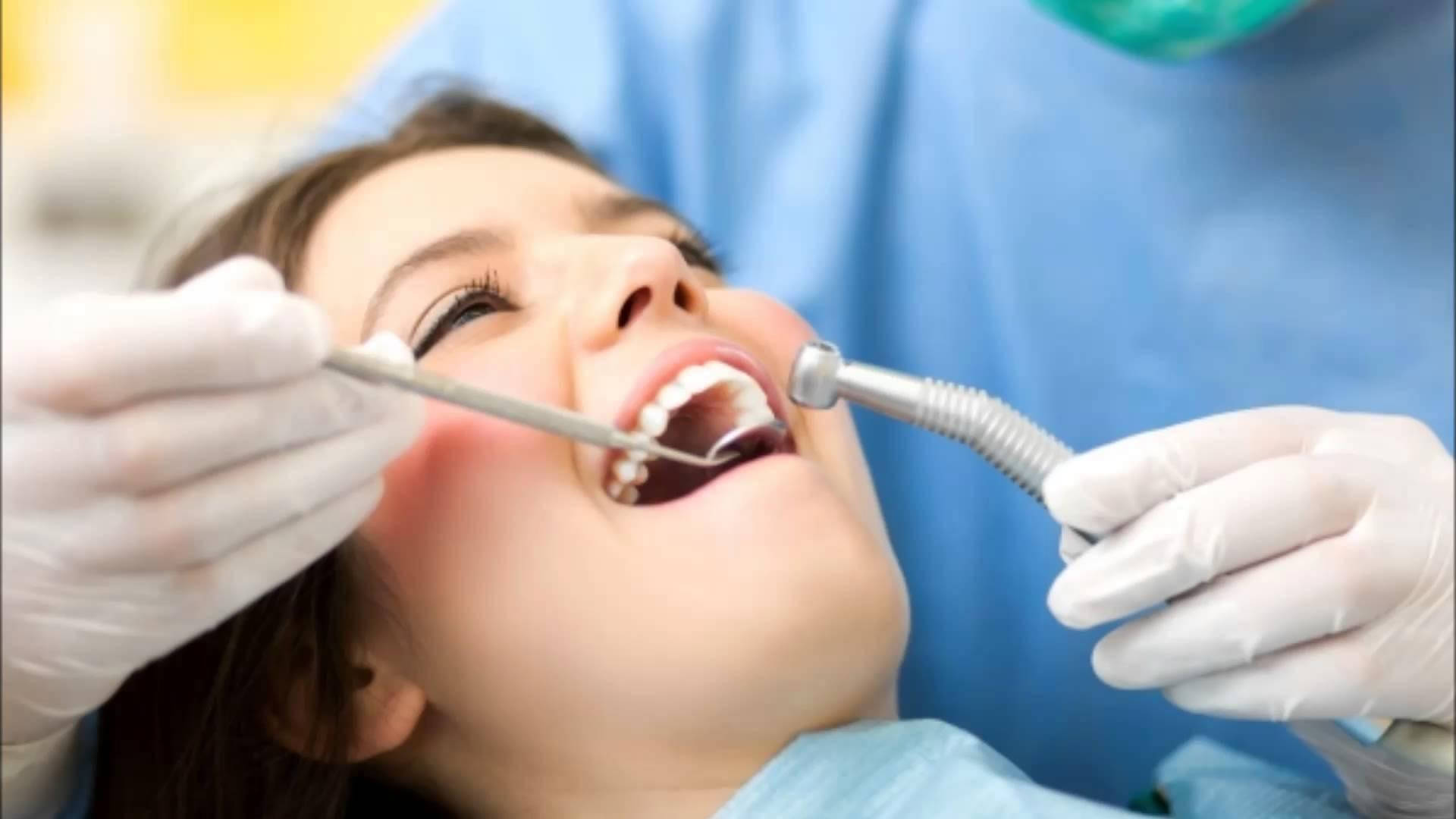 A dentist examining the teeth of an adult woman - Dentist