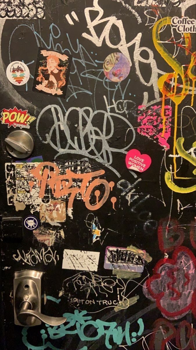 A wall covered in graffiti with various stickers on it - Graffiti, street art