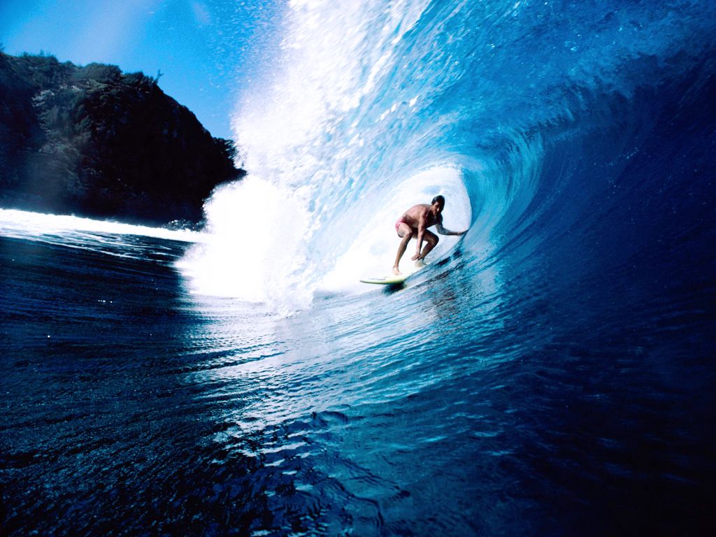 A man on a surfboard riding a wave in the ocean. - Surf