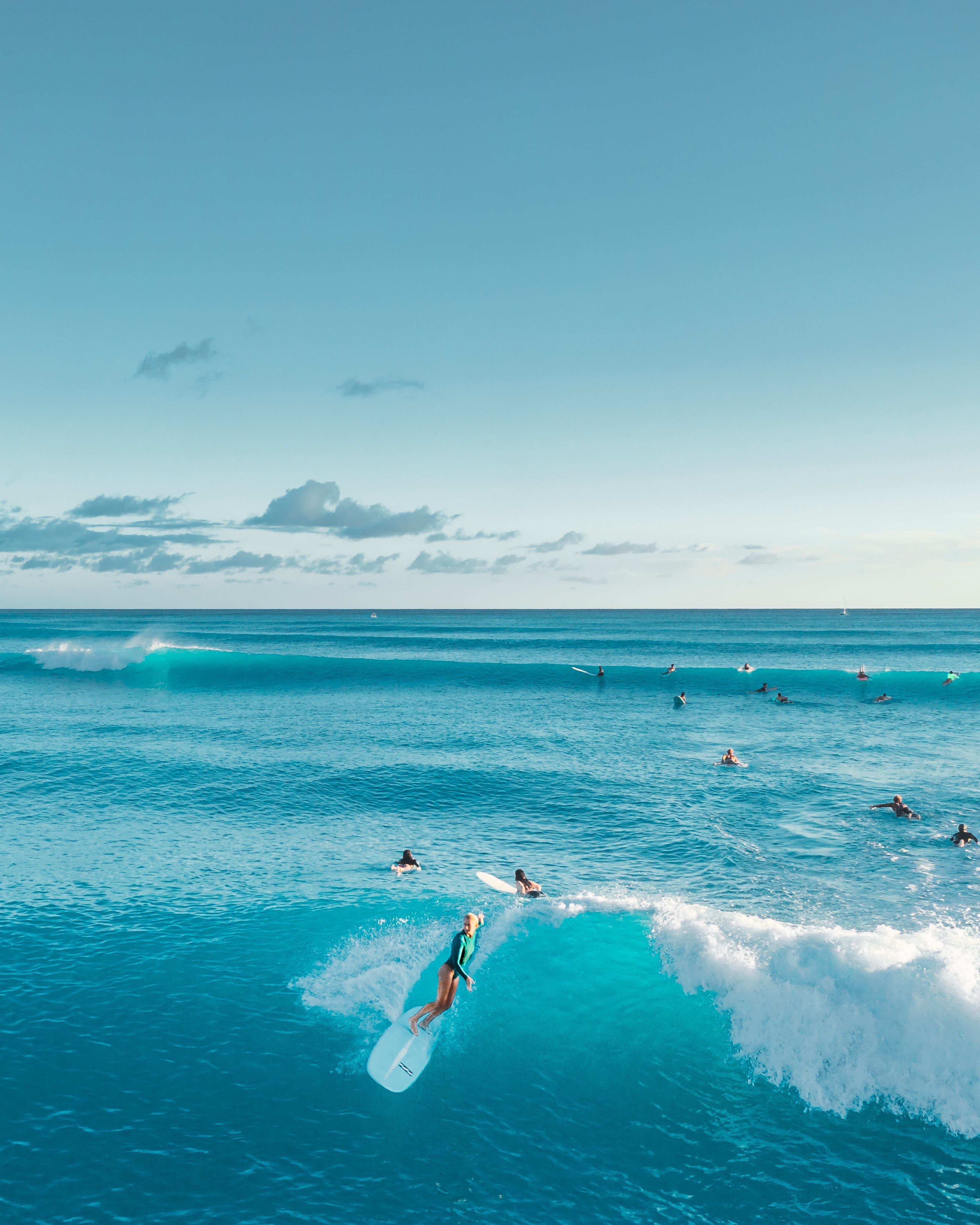 A group of people surfing in the ocean - Surf