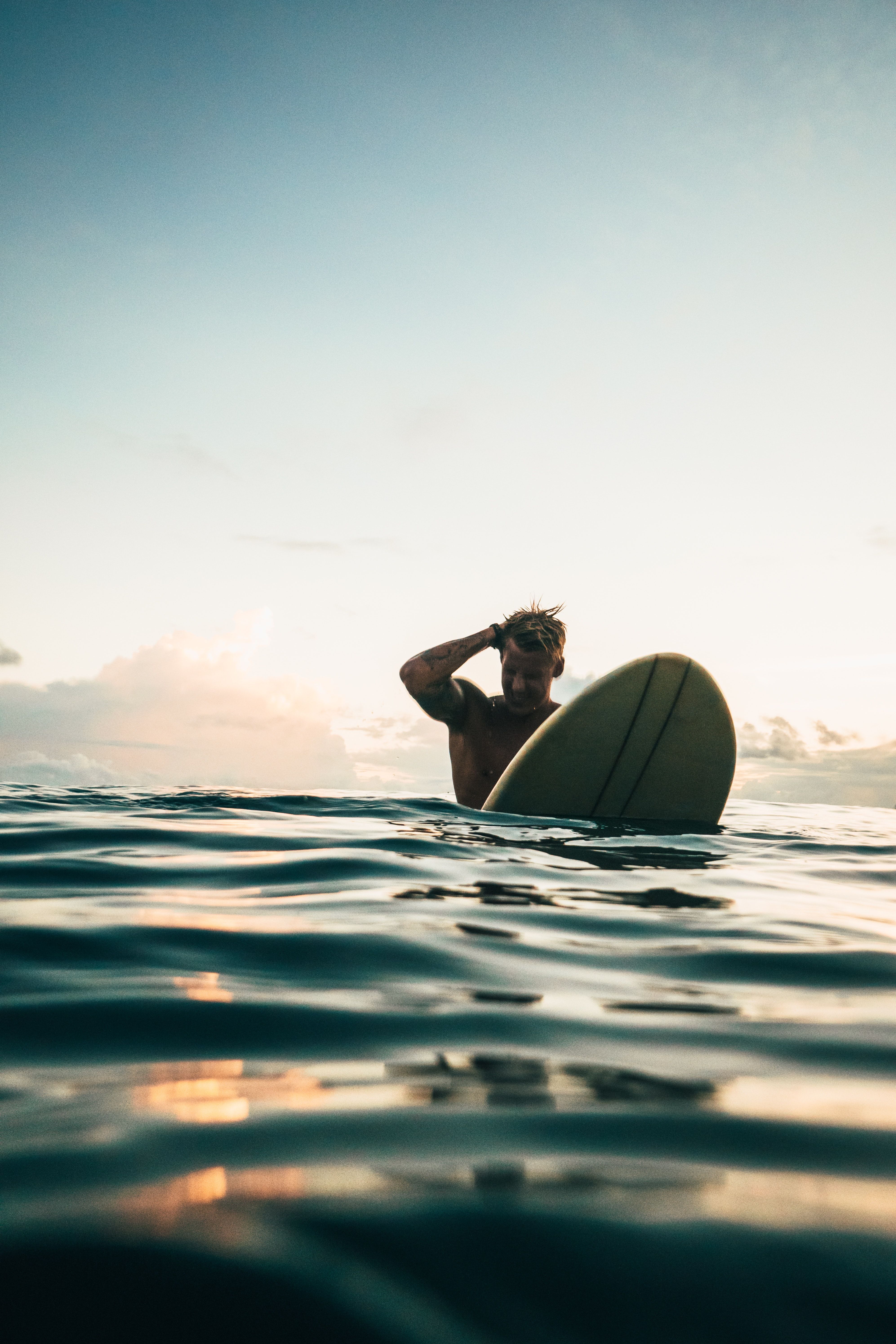 A man is in the water with his surfboard - Surf