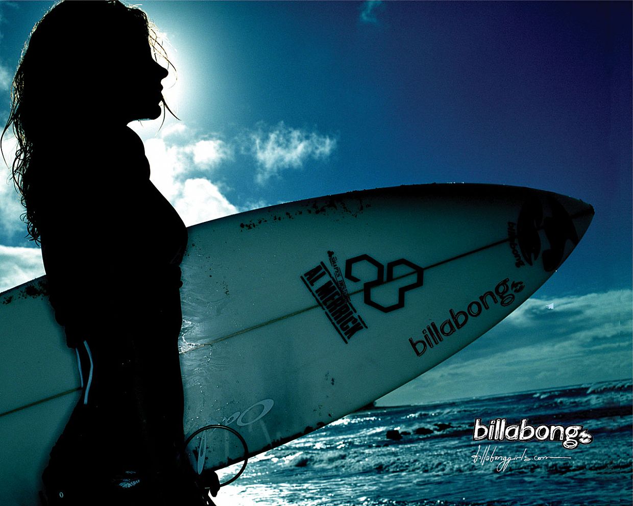 A woman with a surfboard looks out at the ocean. - Surf