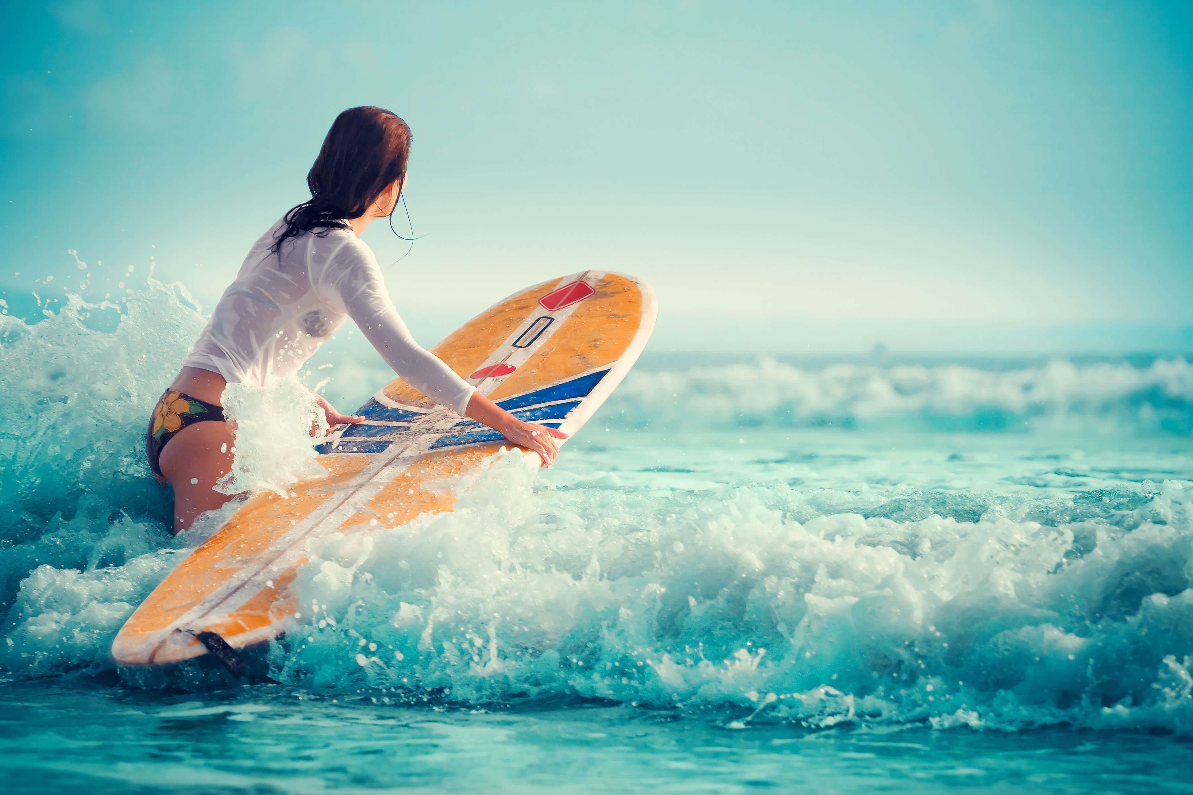 A woman is riding on top of the waves - Surf