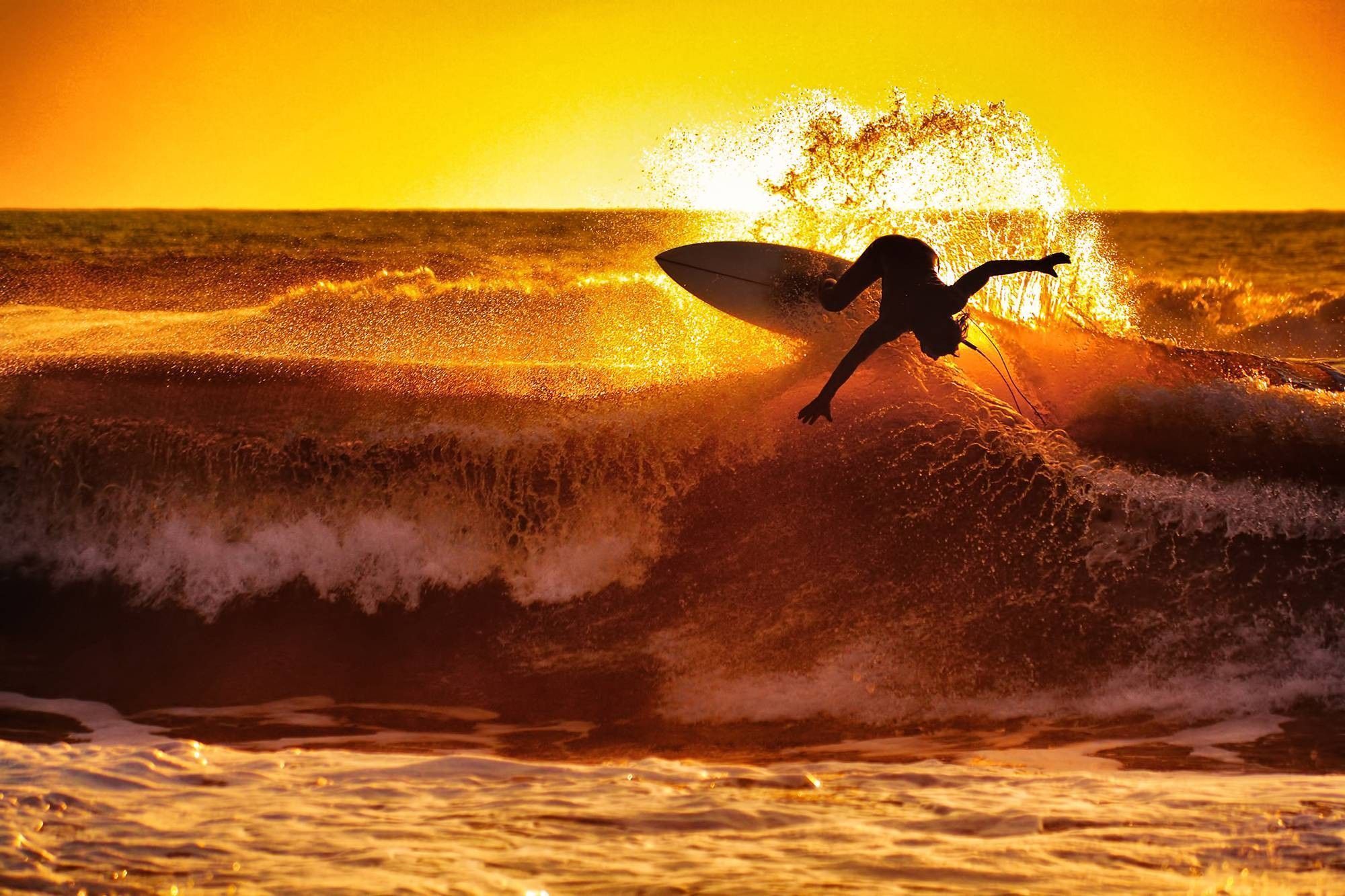 A surfer riding on top of an ocean wave - Surf