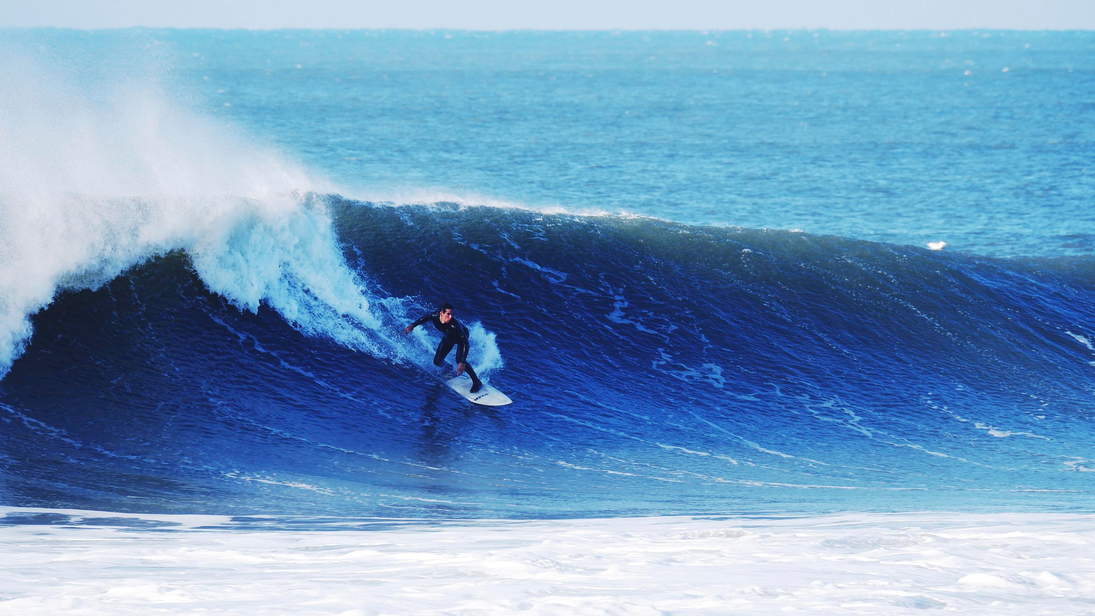 A surfer riding a wave in the ocean - Surf