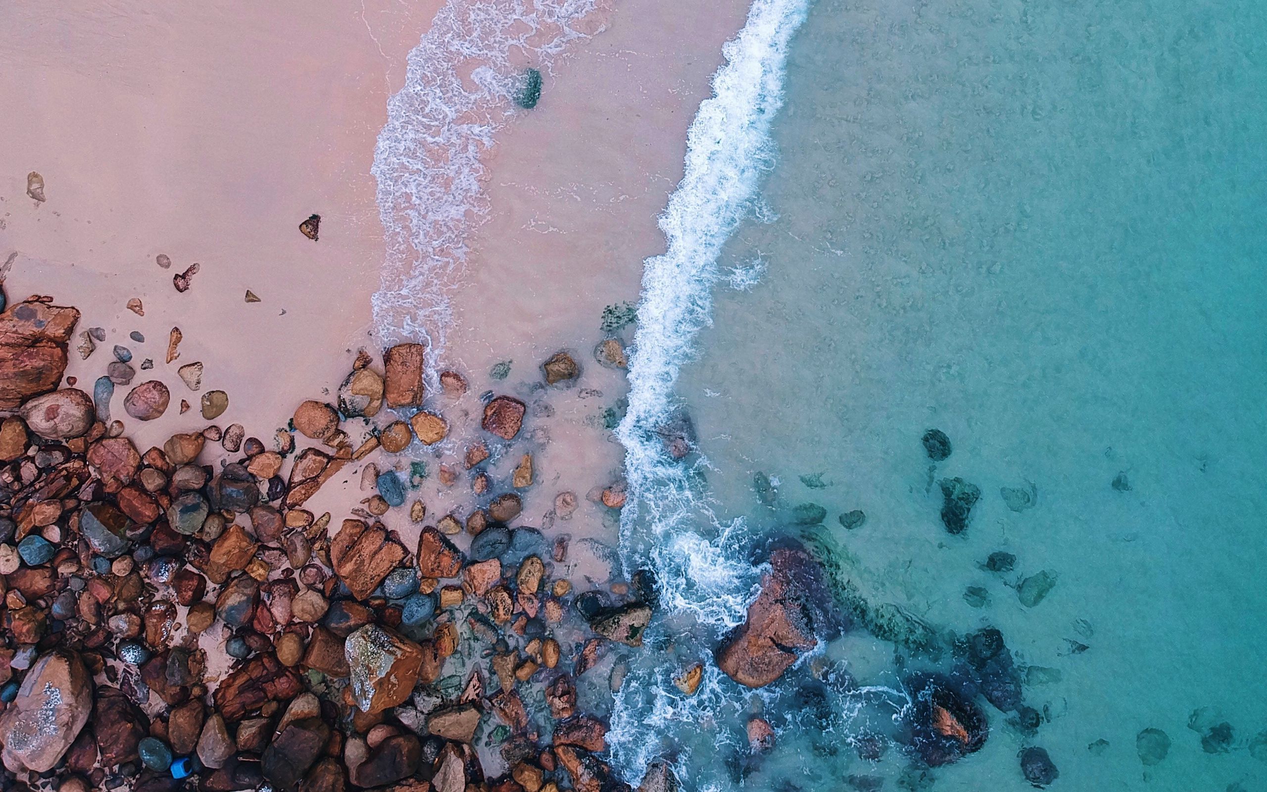 Download wallpaper 2560x1600 ocean, beach, aerial view, sand, stones, surf, foam widescreen 16:10 HD background