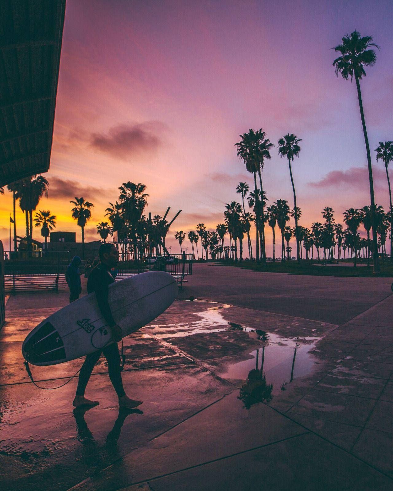 A man walking with his surfboard in the rain - Surf