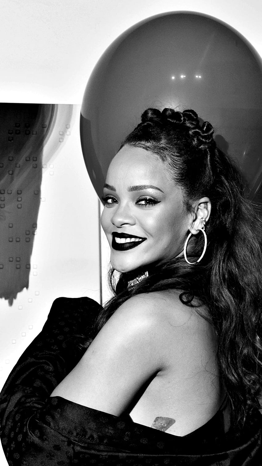 A woman with black lipstick and big earrings - Rihanna