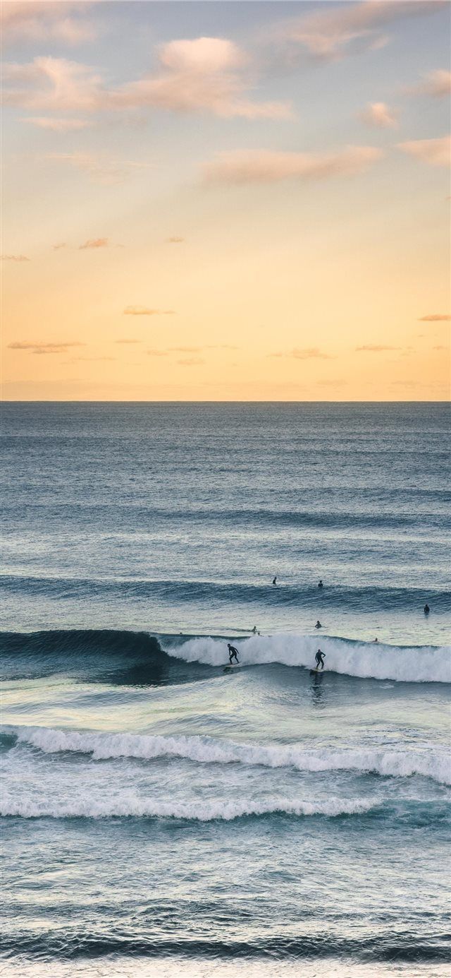 A group of people surfing in the ocean - Surf