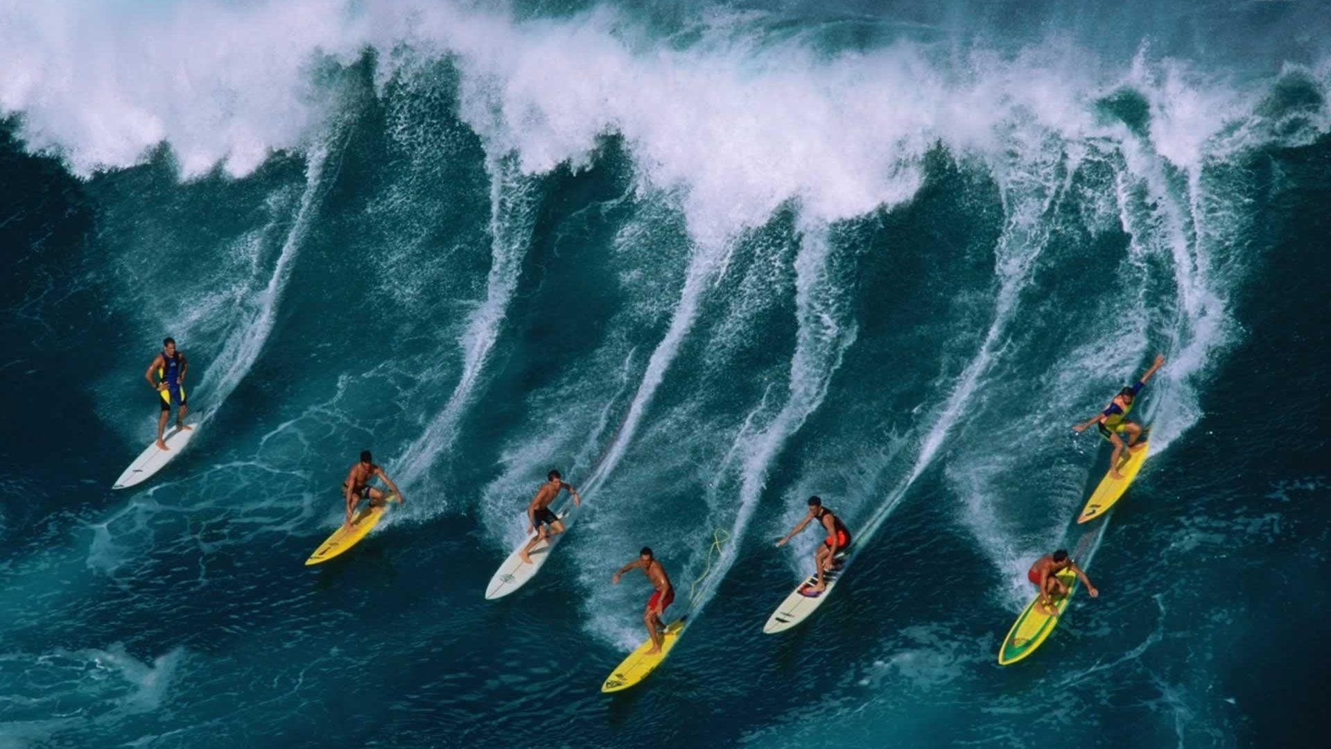 A group of surfers riding the waves - Surf