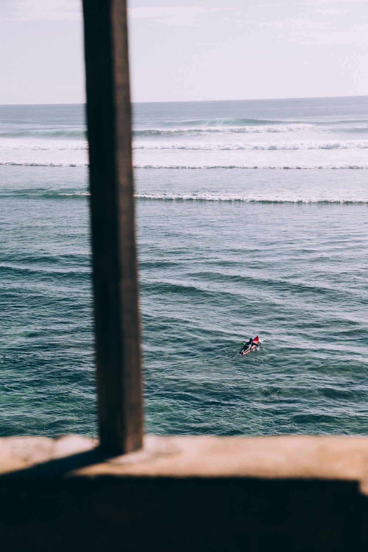 A surfer paddles out into the ocean. - Surf