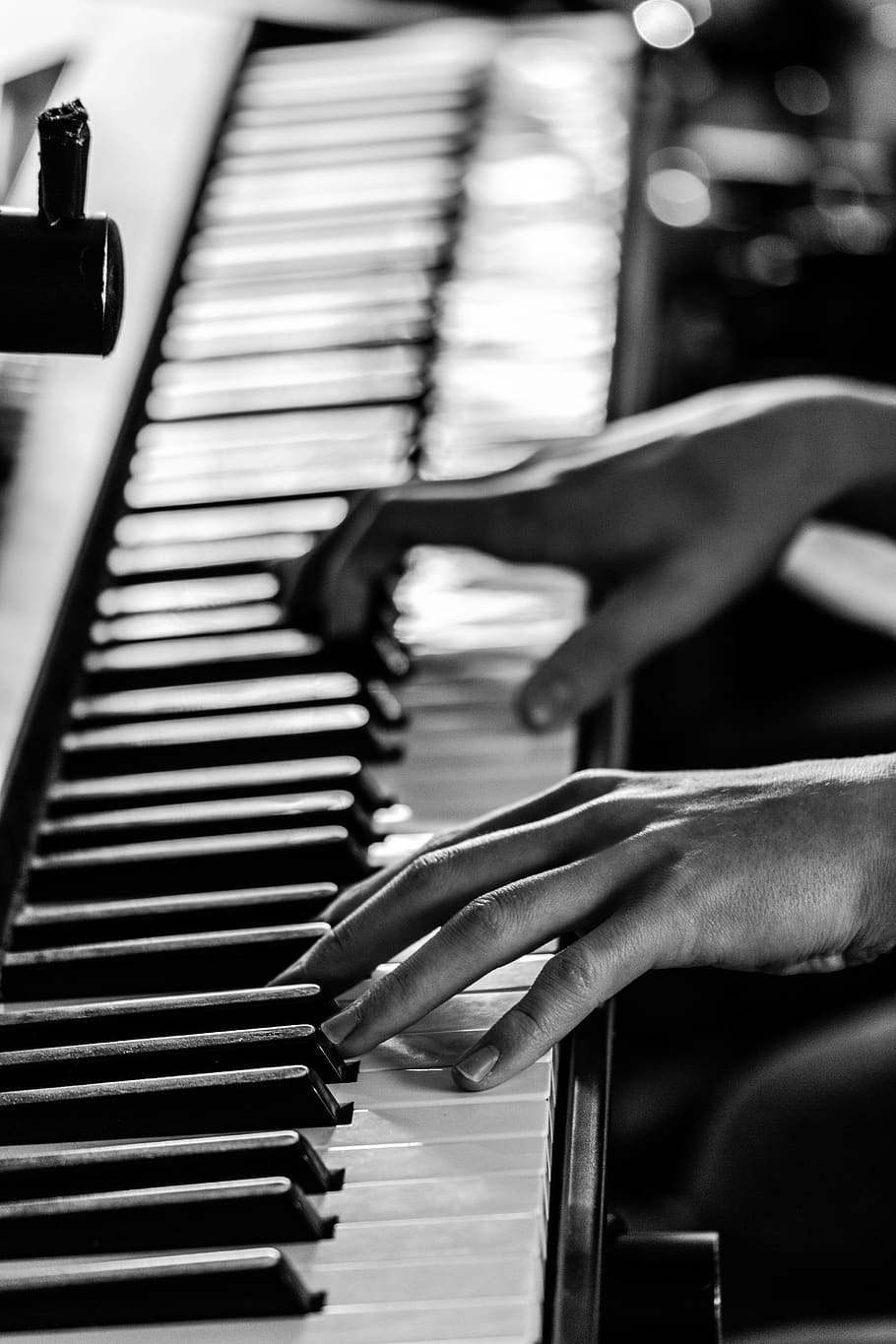 A black and white photo of hands playing the piano - Piano