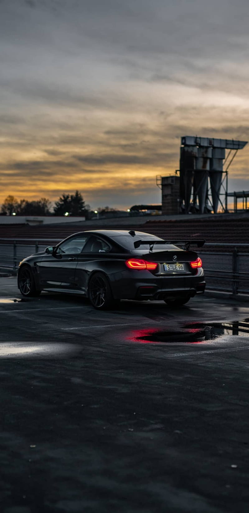 A black BMW car parked on a parking lot during sunset - BMW