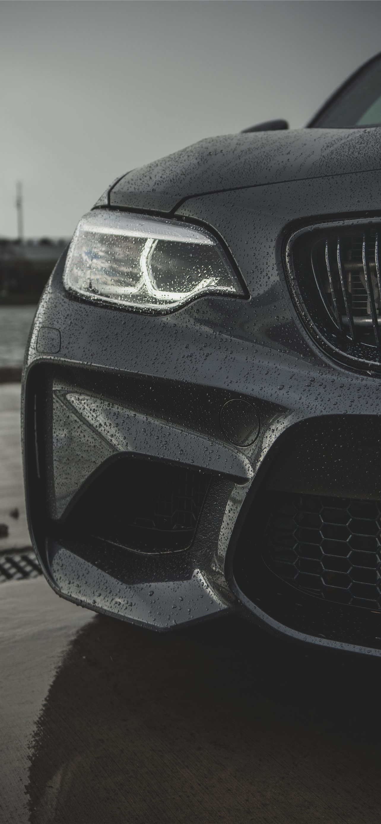A black BMW M2 with water droplets on it - BMW