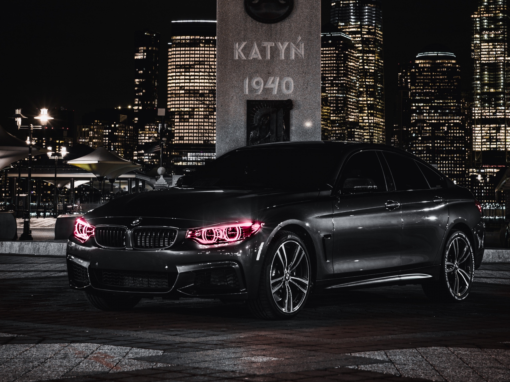 A black BMW 4 series in a city at night. - BMW