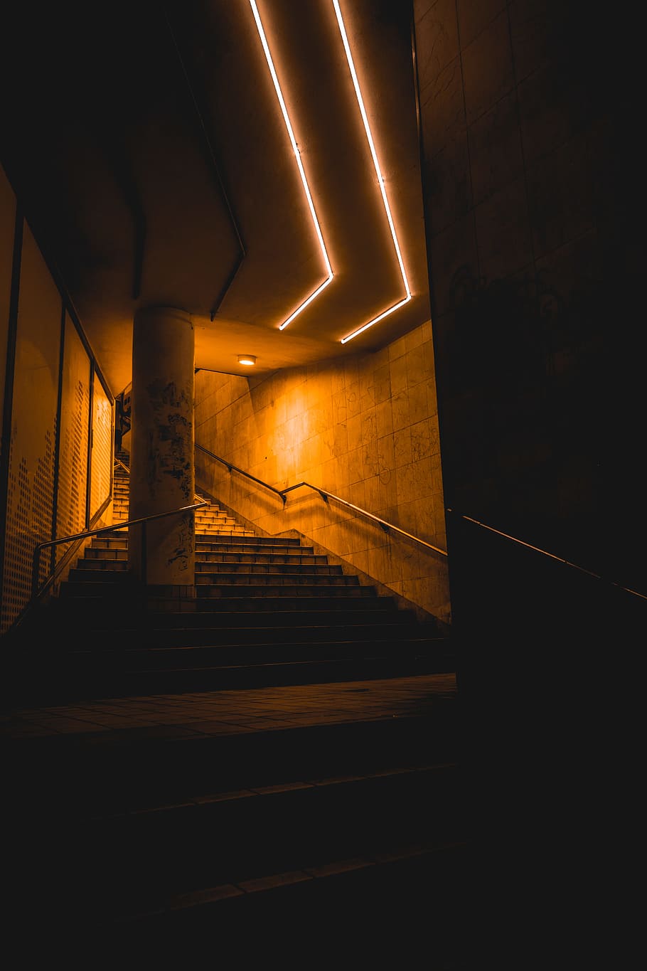 A staircase with neon lights underneath it - Dark orange
