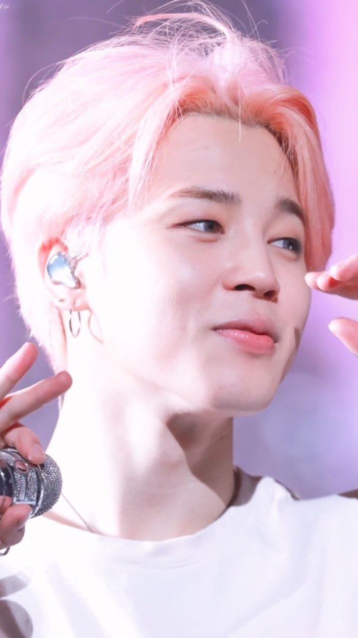 A picture of a K-pop idol with pink hair - Jimin