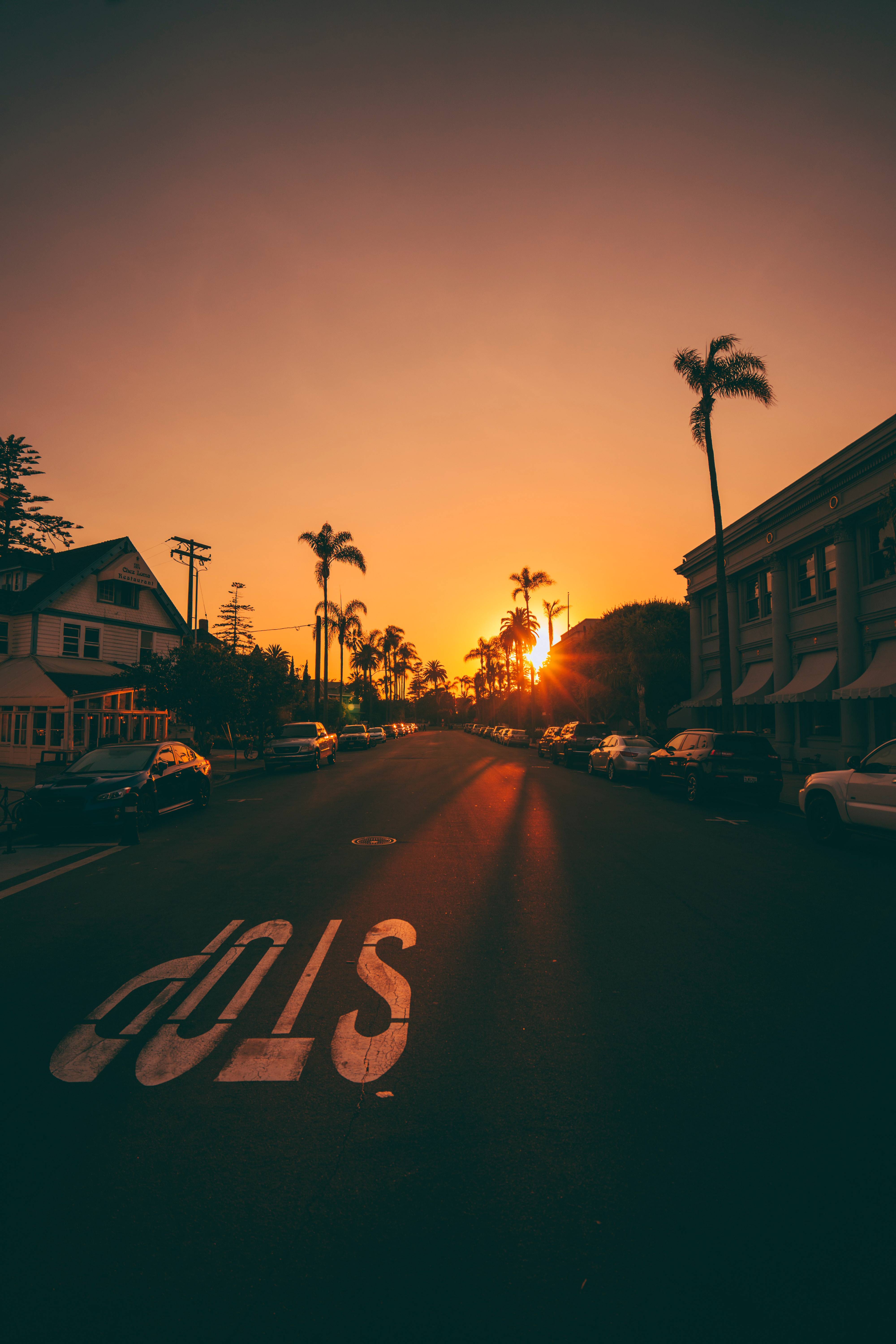 A street with cars parked on it at sunset - Sunrise