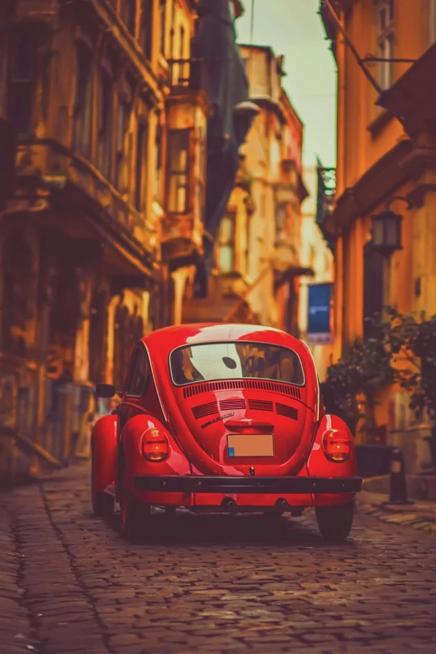 A red car parked on a street in a city - Cars