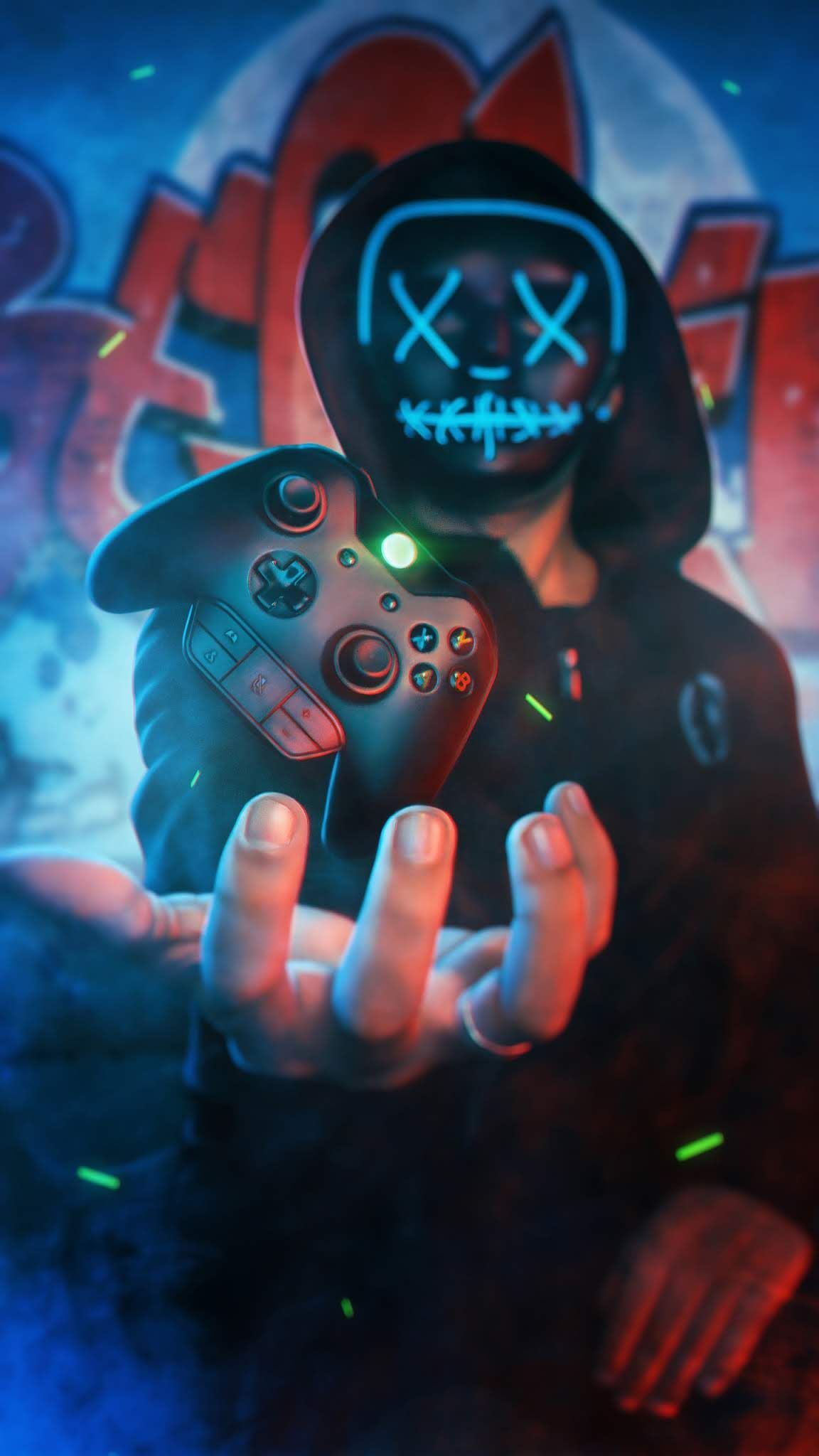 A man in a black hoodie and a neon mask holding a video game controller - Gaming