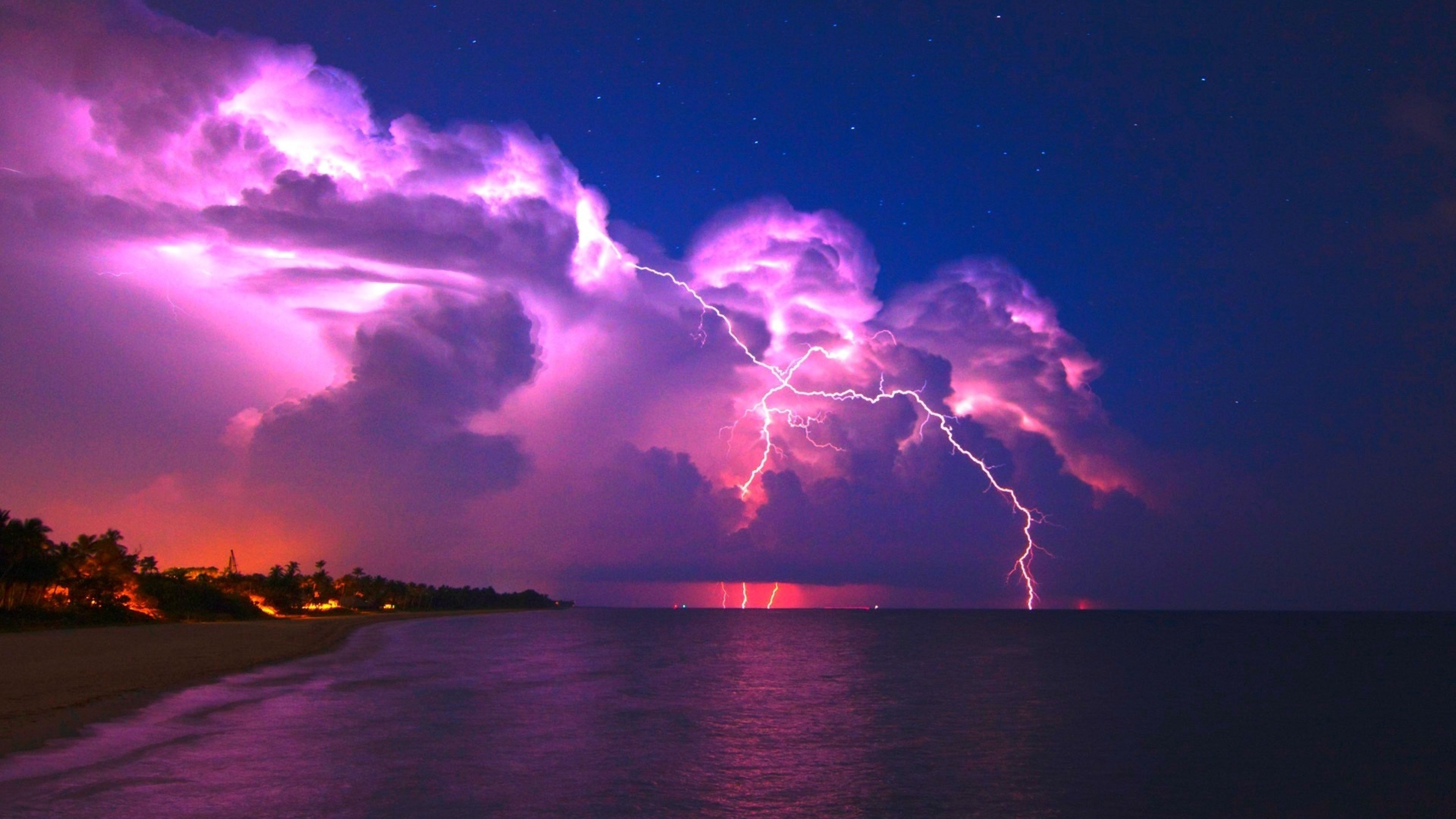 A purple lightning bolt strikes the sky over water - Lightning, storm