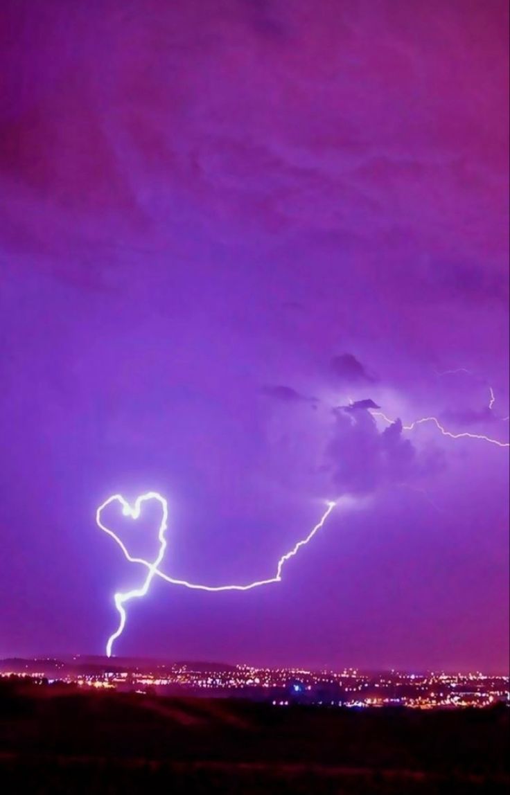 A lightning bolt in the sky with purple clouds - Lightning