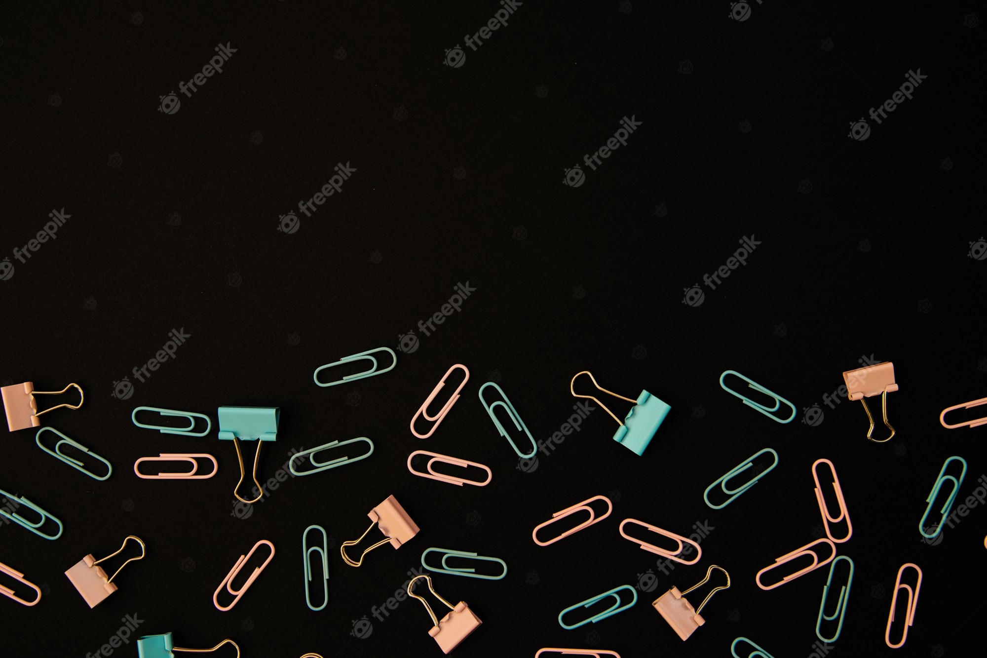 A background of paper clips on black - School