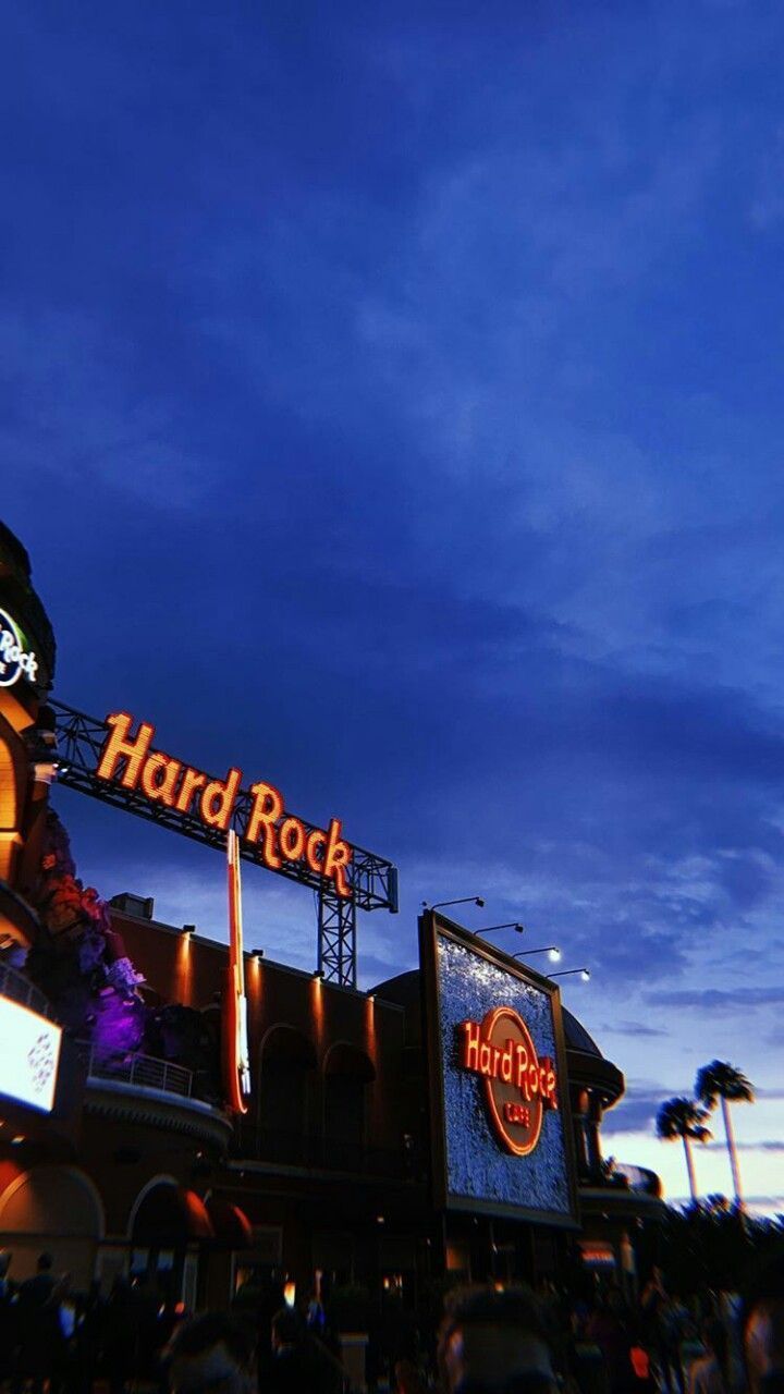 Hard Rock Cafe sign lit up at night with a blue sky - Rock