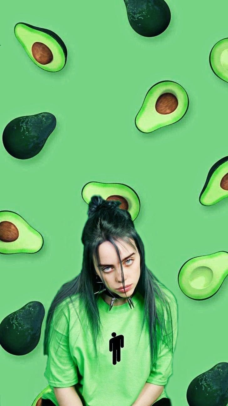 A woman in green shirt sitting on the ground with avocados - Avocado