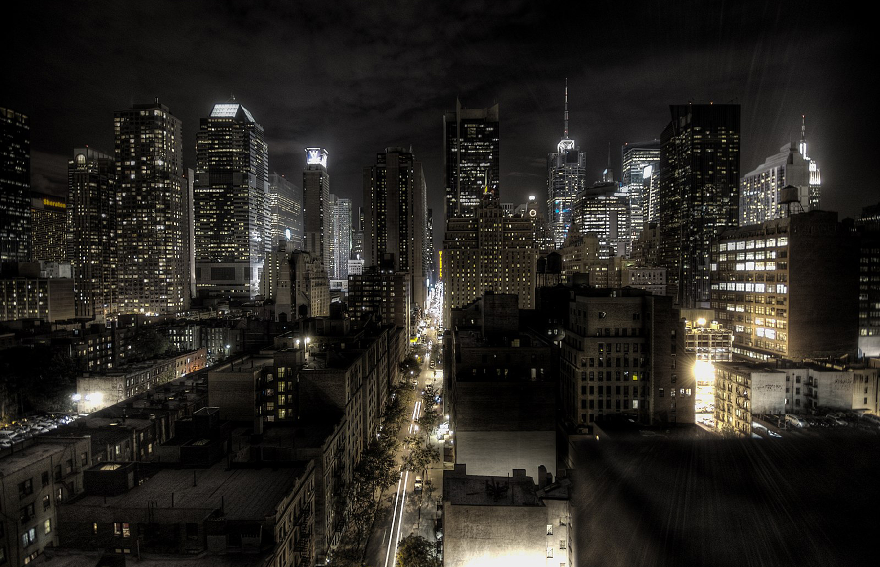 A dark city skyline at night with streetlights illuminating the road - New York