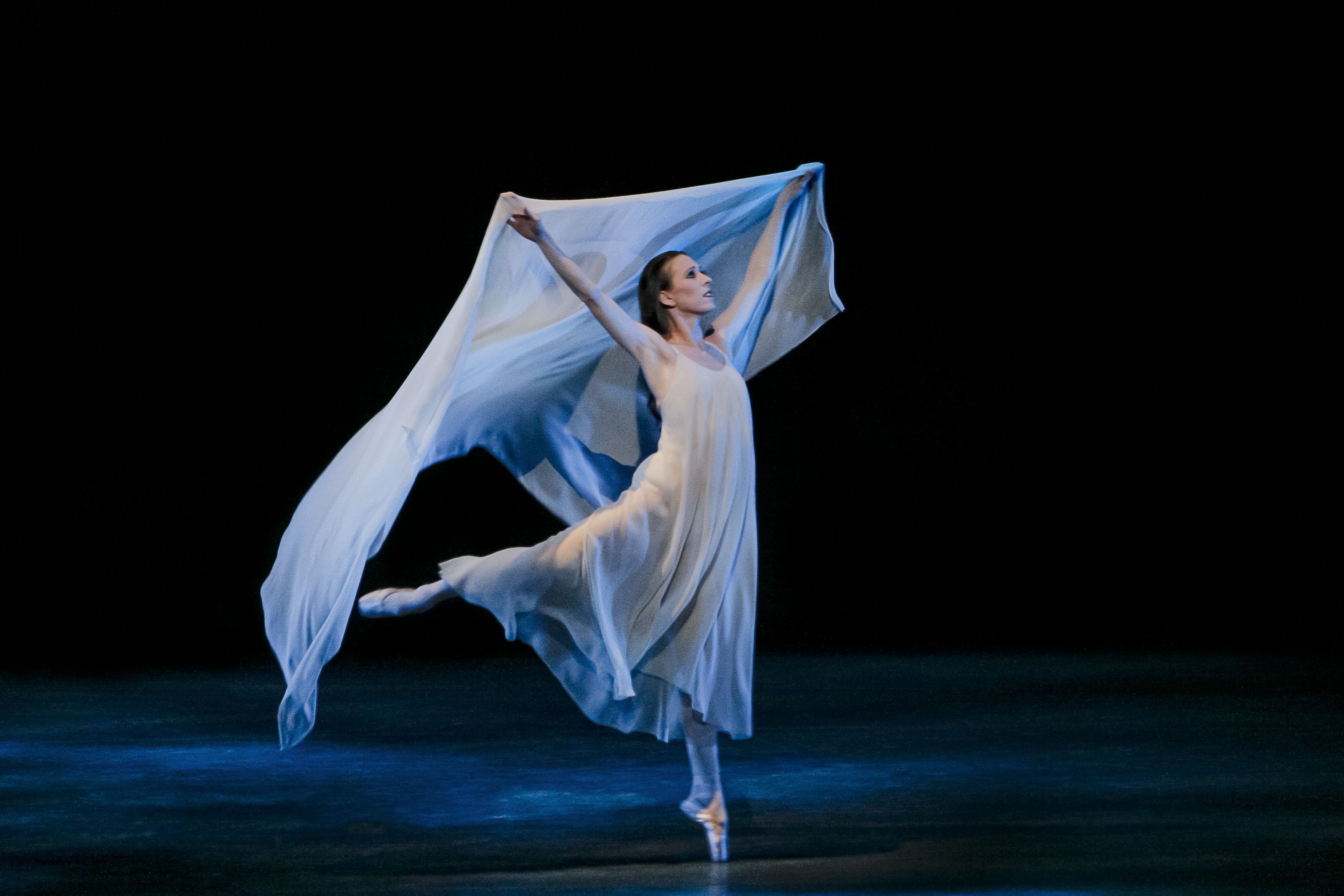 A woman in white is dancing on stage - Ballet