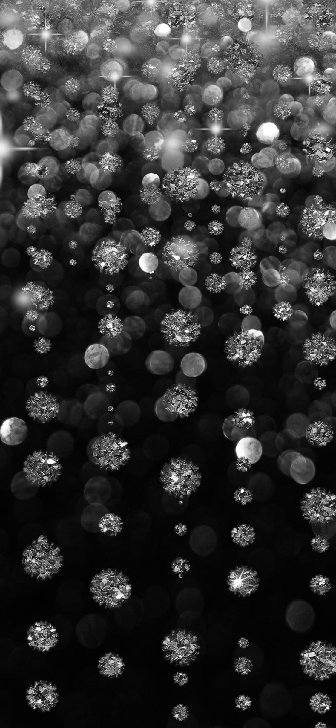 A black and white photo of snowflakes falling - Diamond