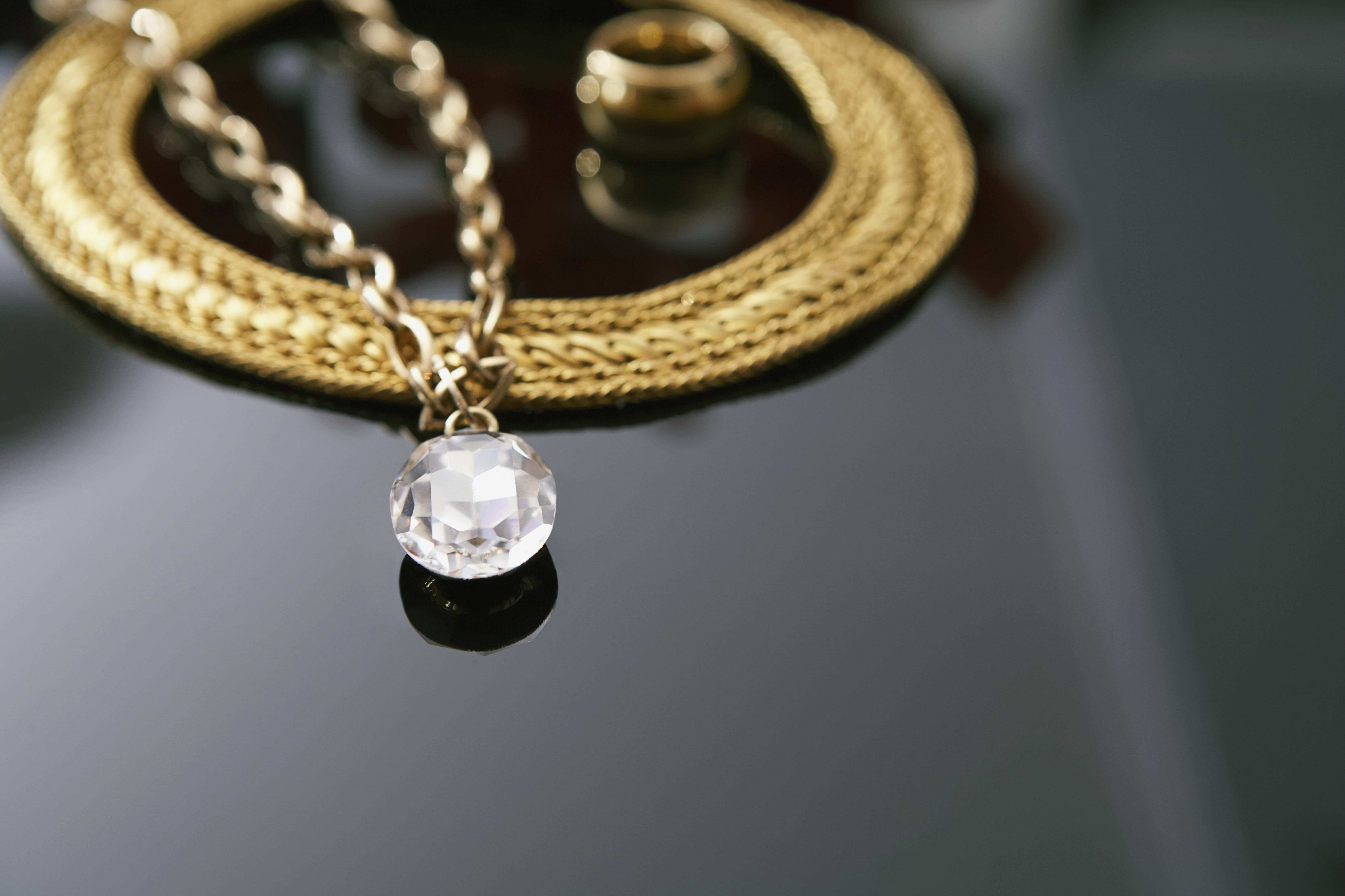 A gold necklace with a large diamond. - Diamond