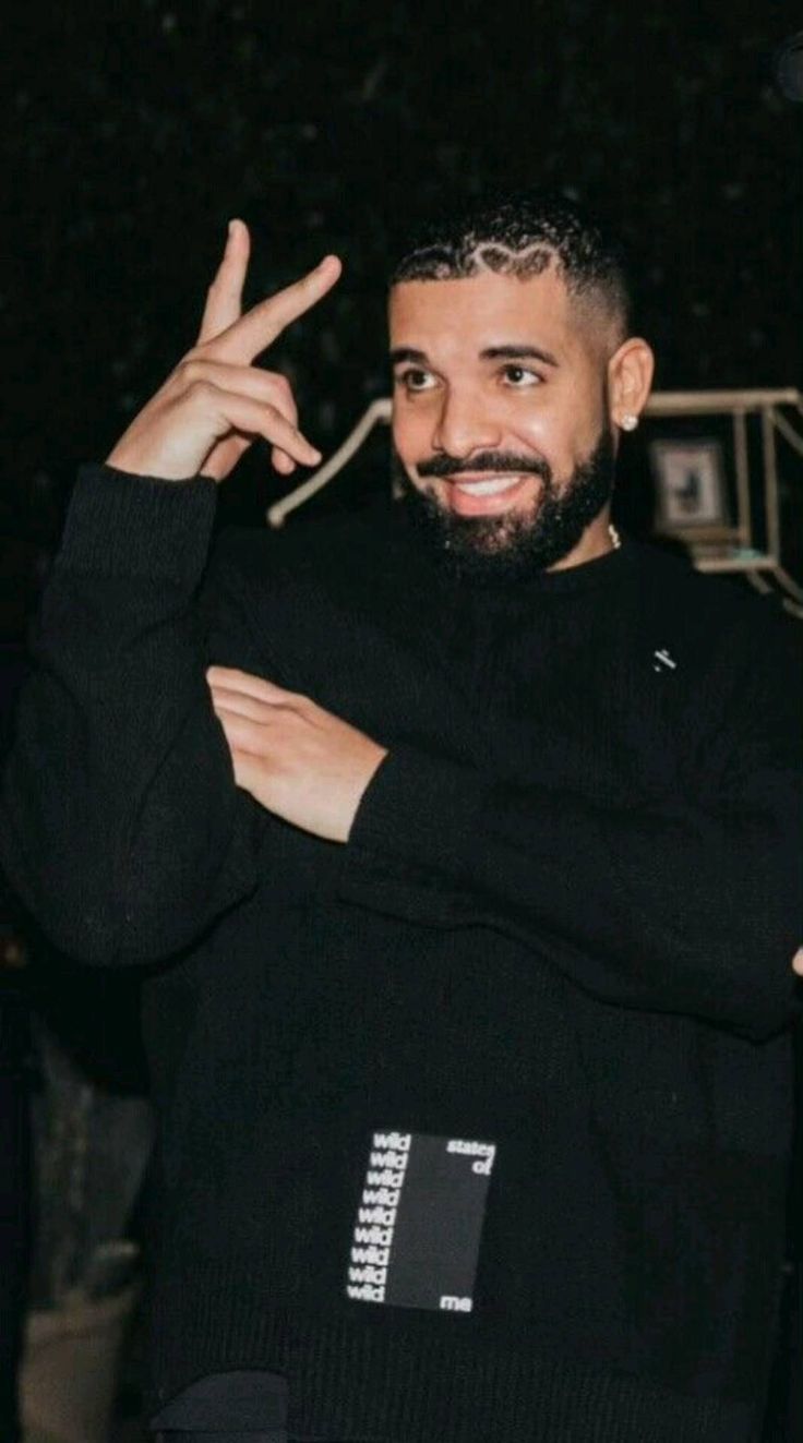 A man in black is making the peace sign - Drake