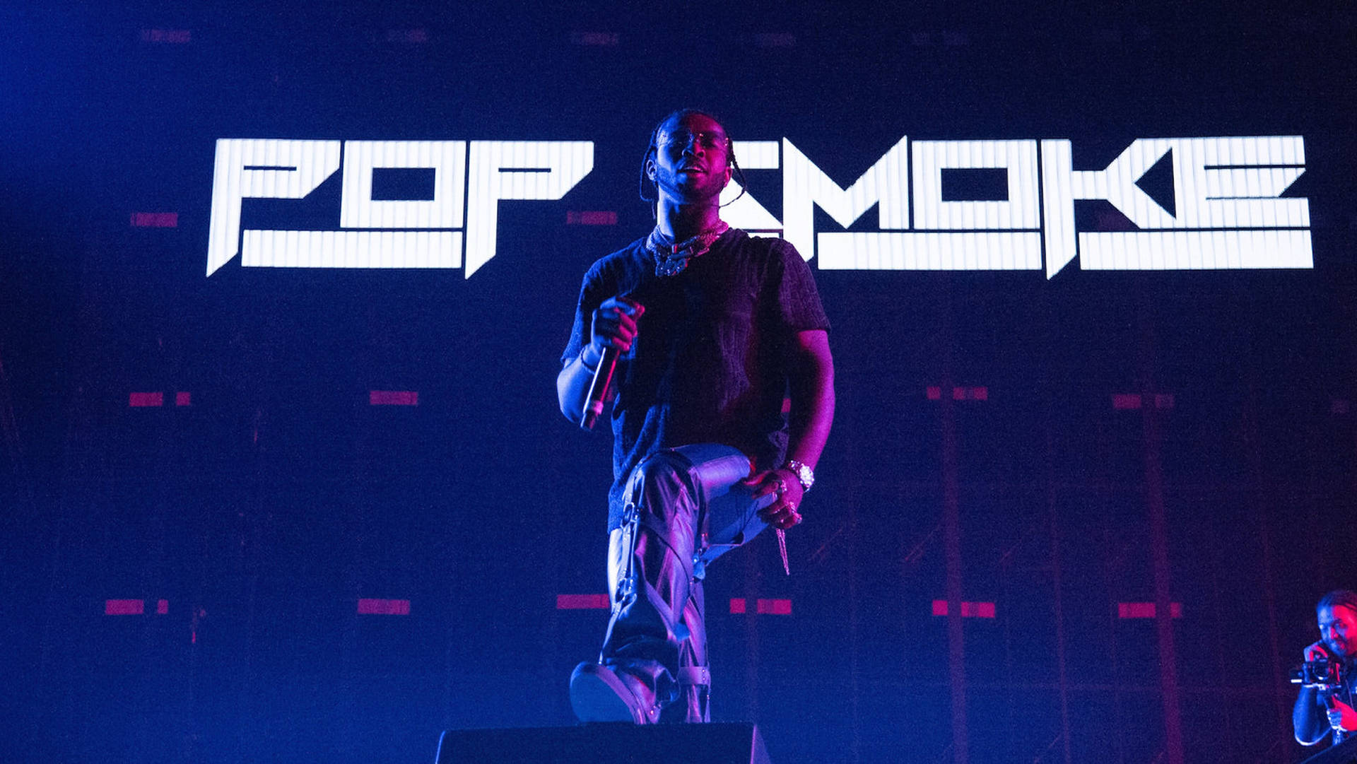 A man standing on stage with his arms crossed - Pop Smoke