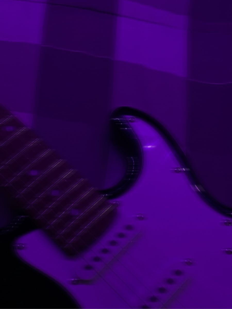 A purple guitar is sitting on the floor - Guitar
