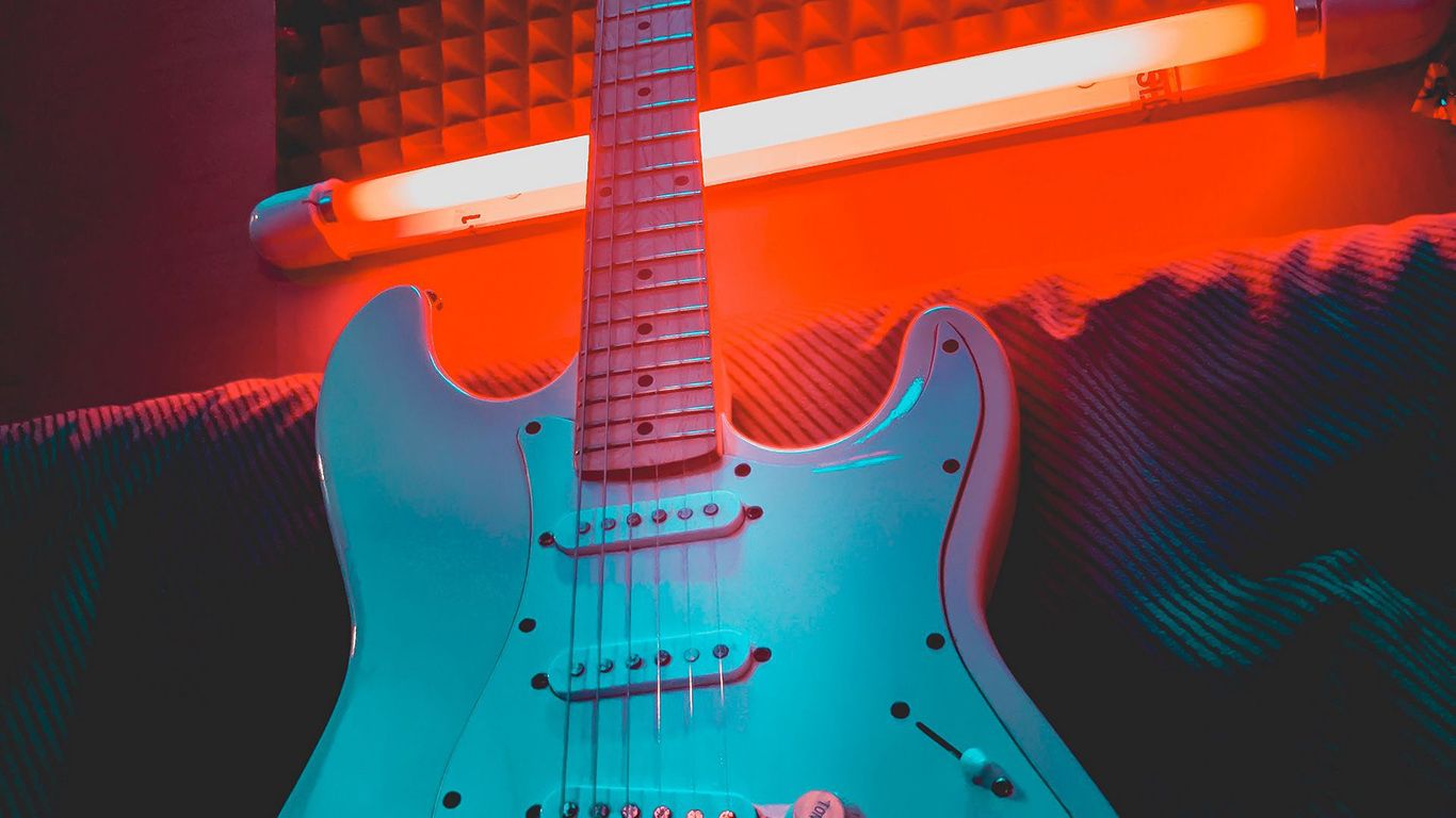 A guitar is sitting on top of some speakers - Guitar