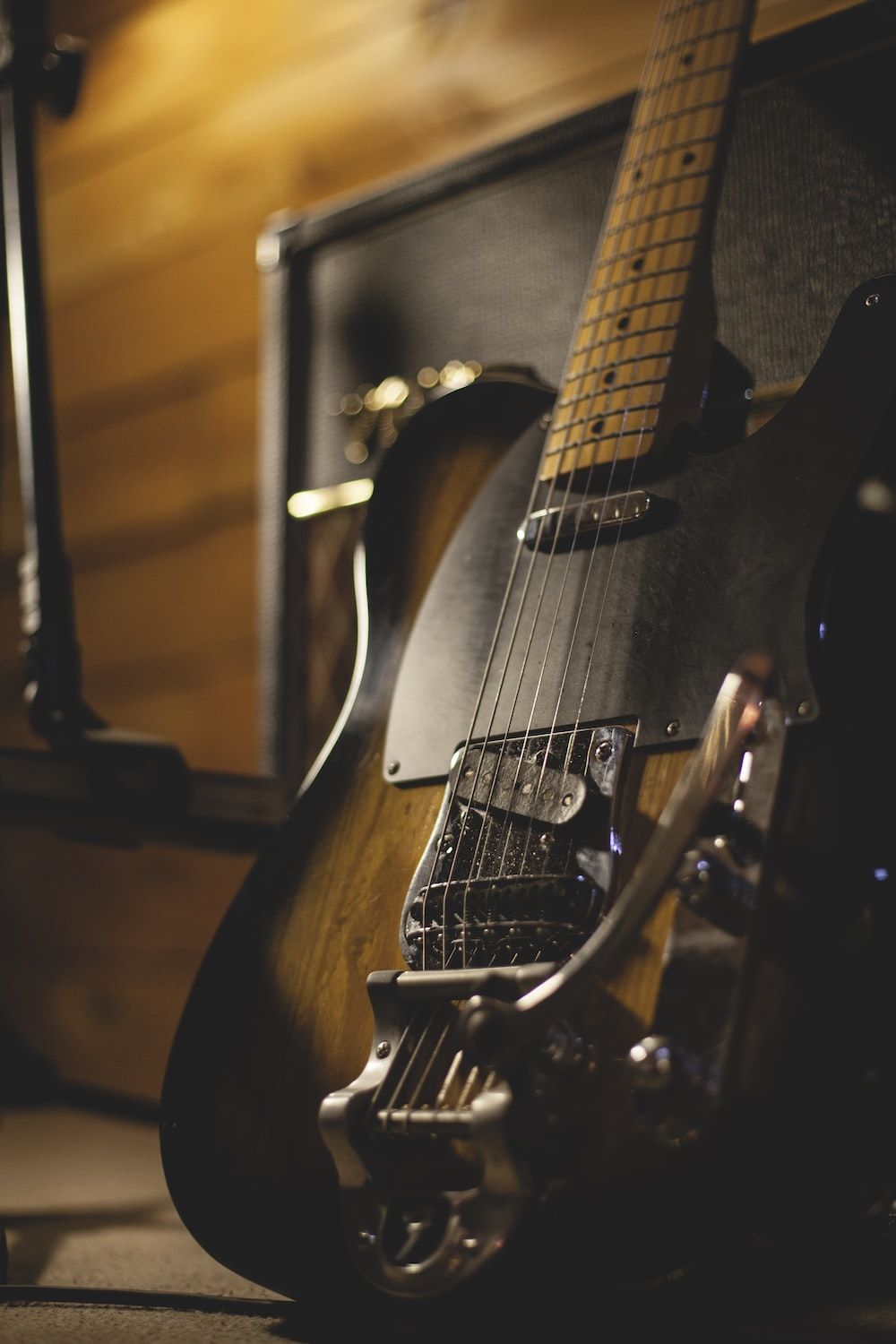 A guitar is sitting on top of an amplifier - Guitar