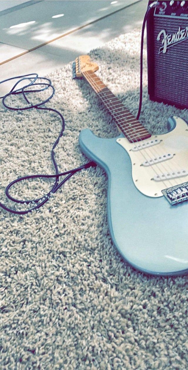 A guitar and amplifier on the floor - Guitar