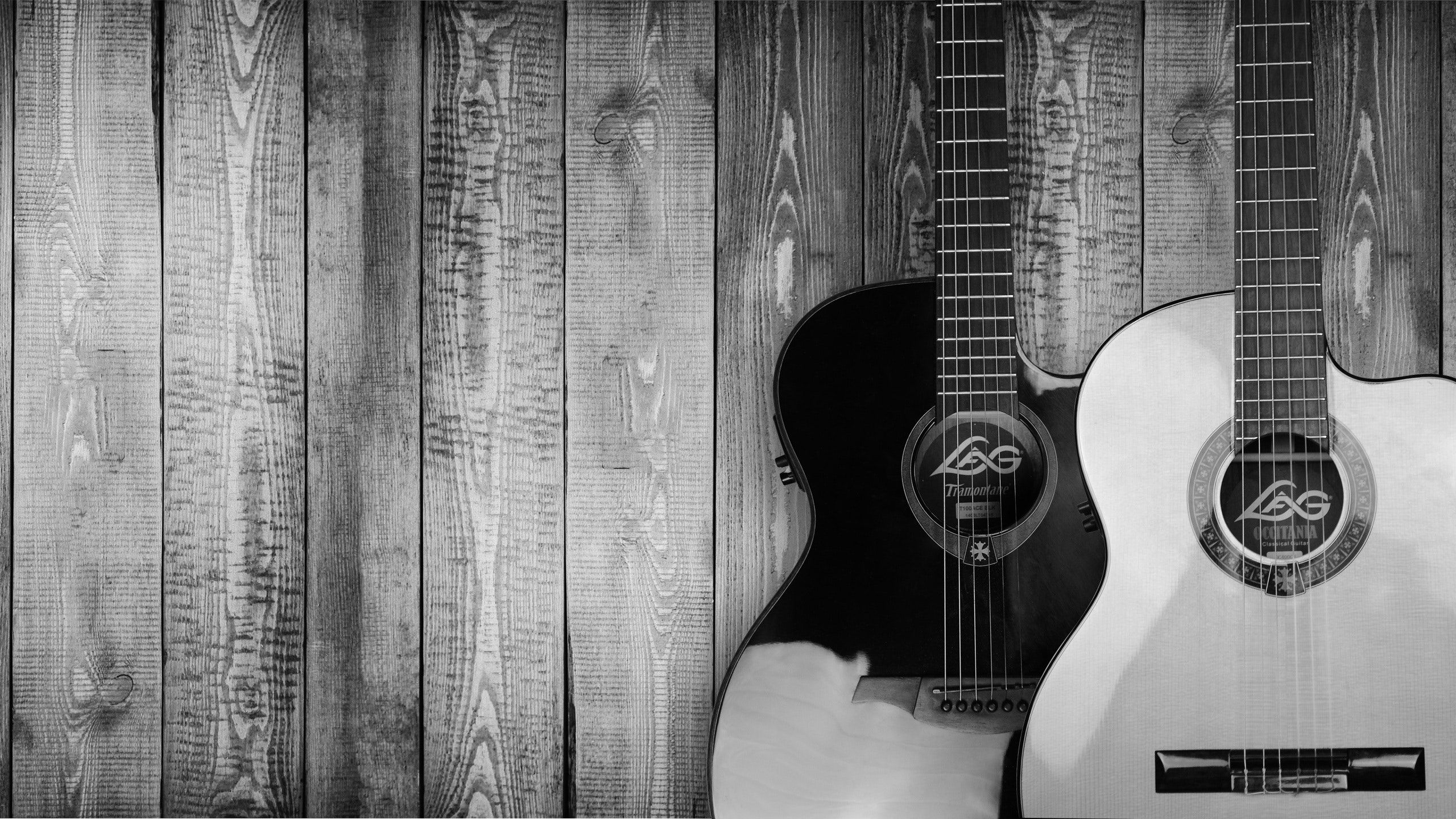 A black and white guitar on a wooden background - Guitar