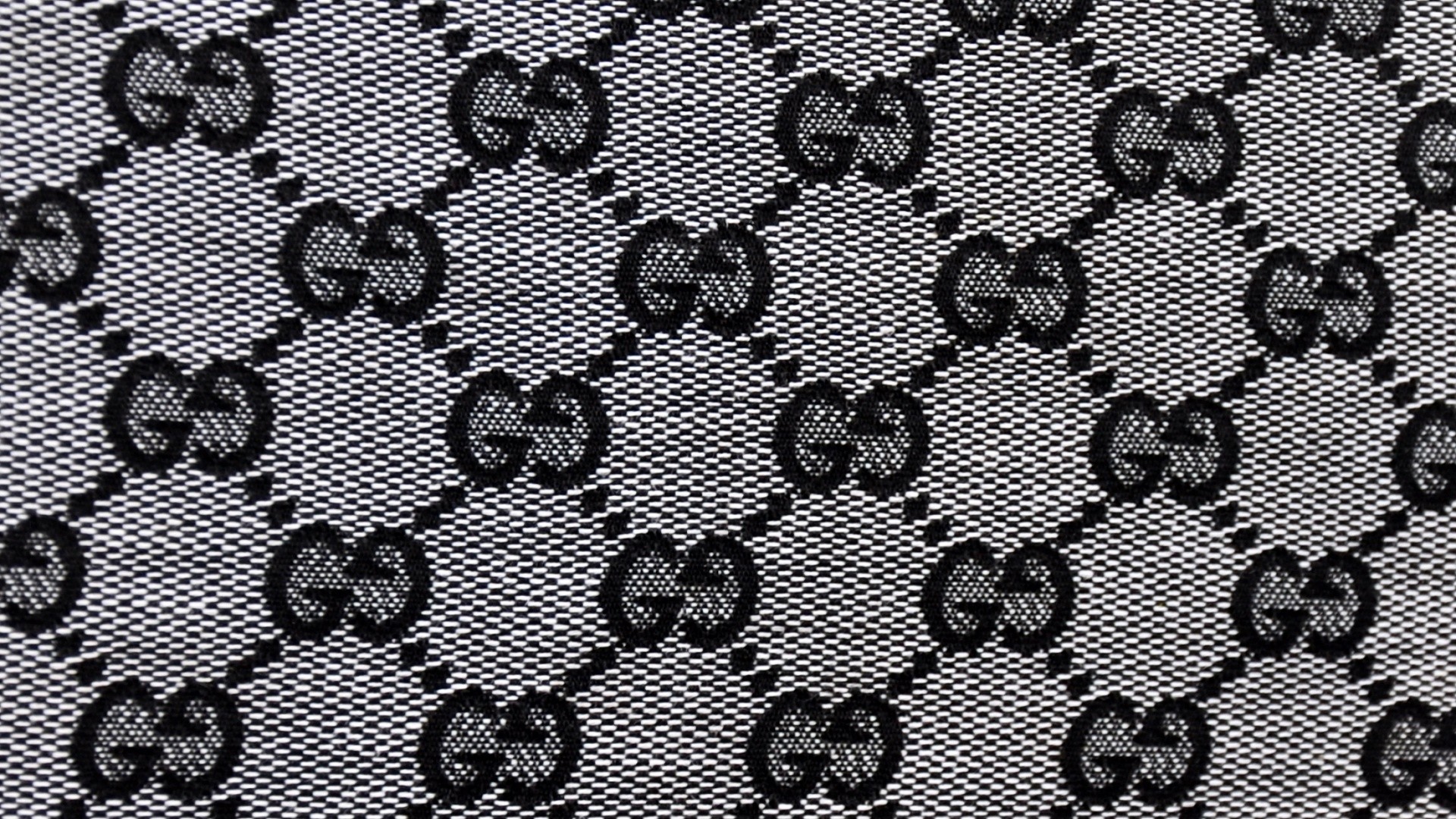 A close up of the gucci logo on black and white fabric - Gucci